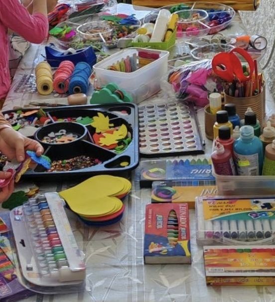 Table covered with yarn, felt shapes, and craft supplies