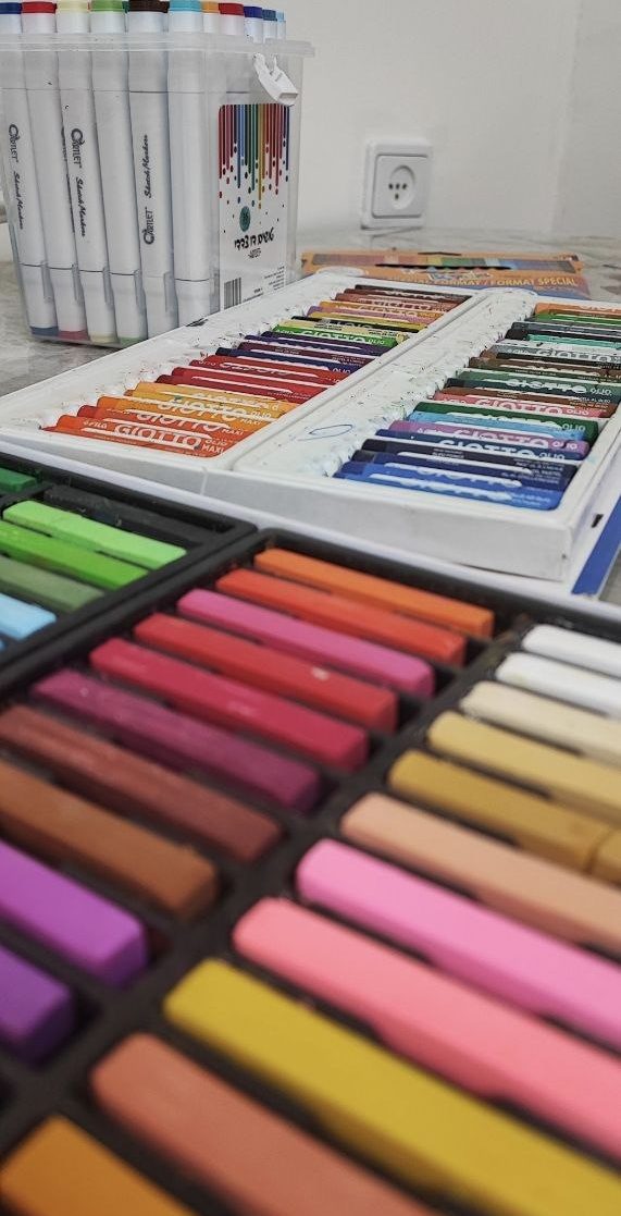 Soft pastels and markers lined up on a table
